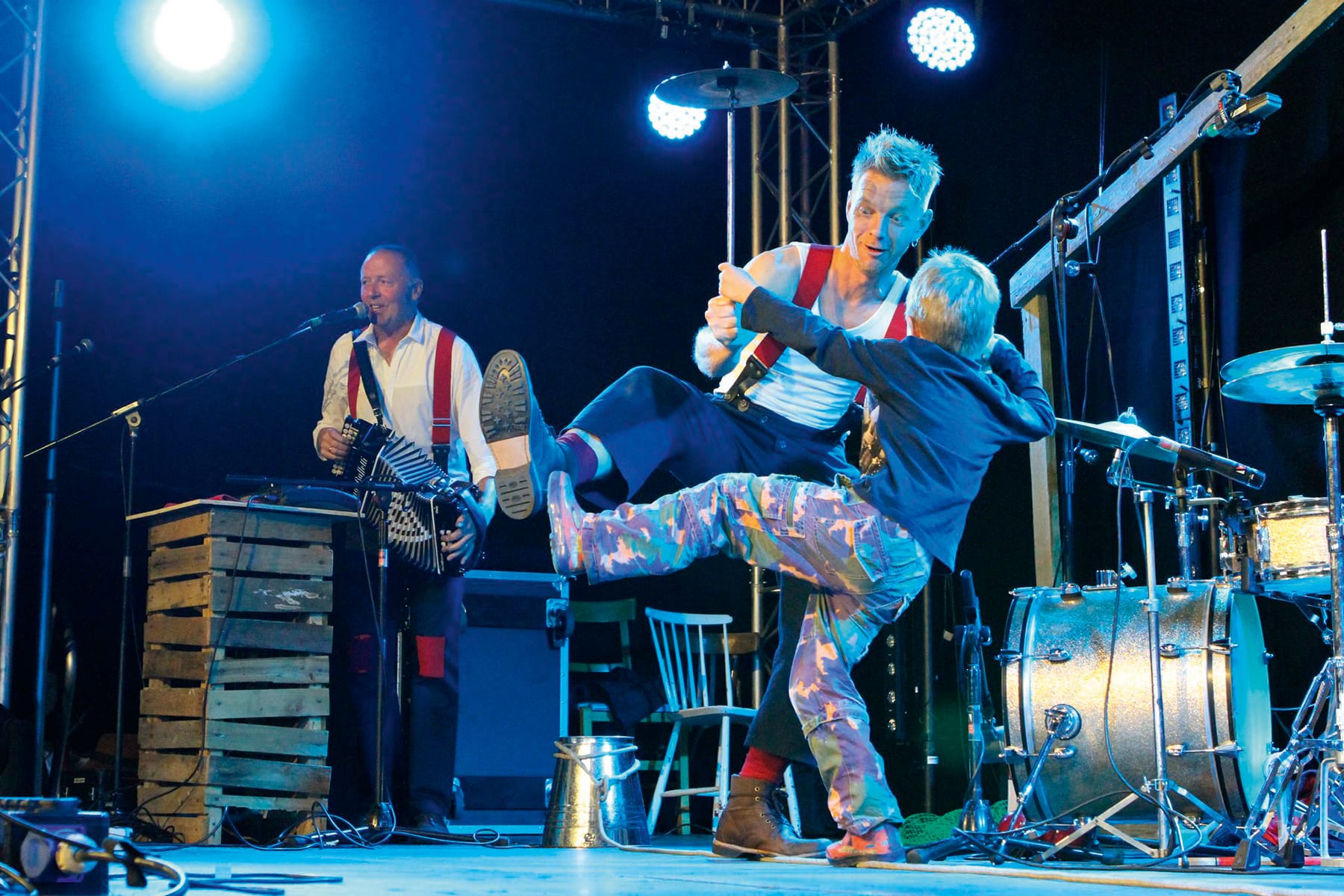 Photograph shows a performer on stage at Towersey Festival dancing with a young child