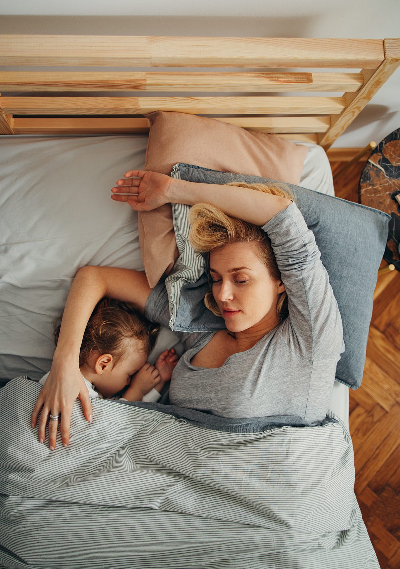 Photograph of a mother and her child in bed, asleep