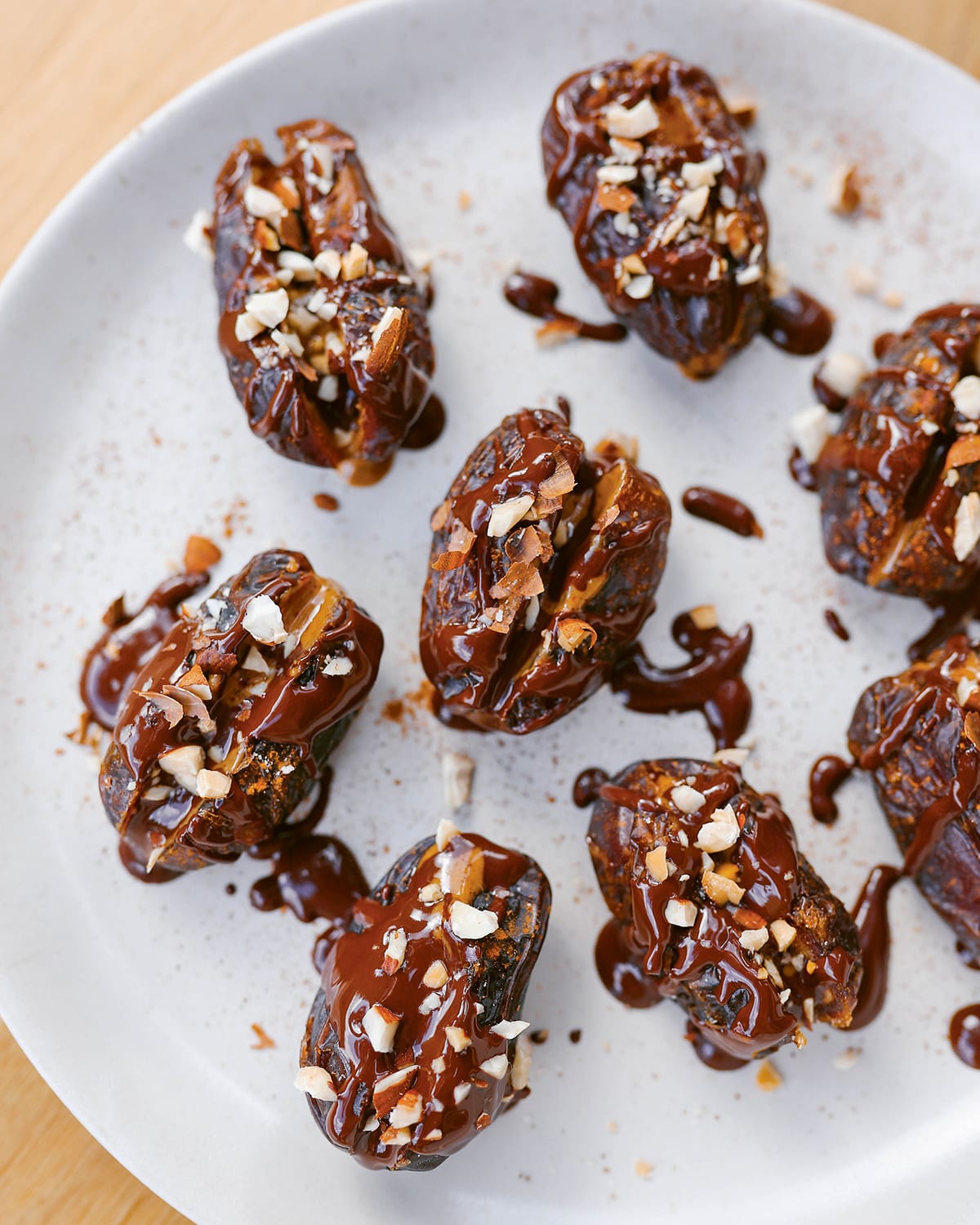 Photo shows a plate of dates stuffed with almond butter and drizzled with chocolate