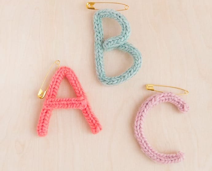 Brightly coloured, French-knitted letters: A, B, C, with pins