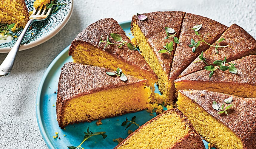Photo of grapefruit, almond and turmeric cake on a plate, cut into slices