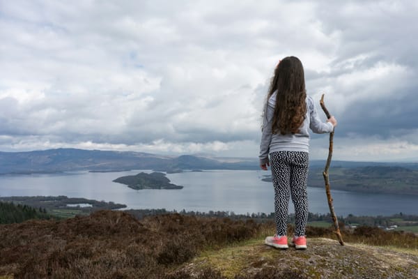 Girl standing and looking out over coastline