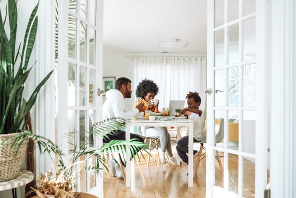 Photograph of a family sitting at a dining table eating breakfast together