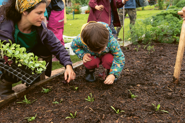 Photograph of a woman and child practicing the no-dig method of gardening