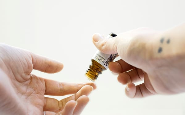 Photograph of hands holding an essential oil bottle